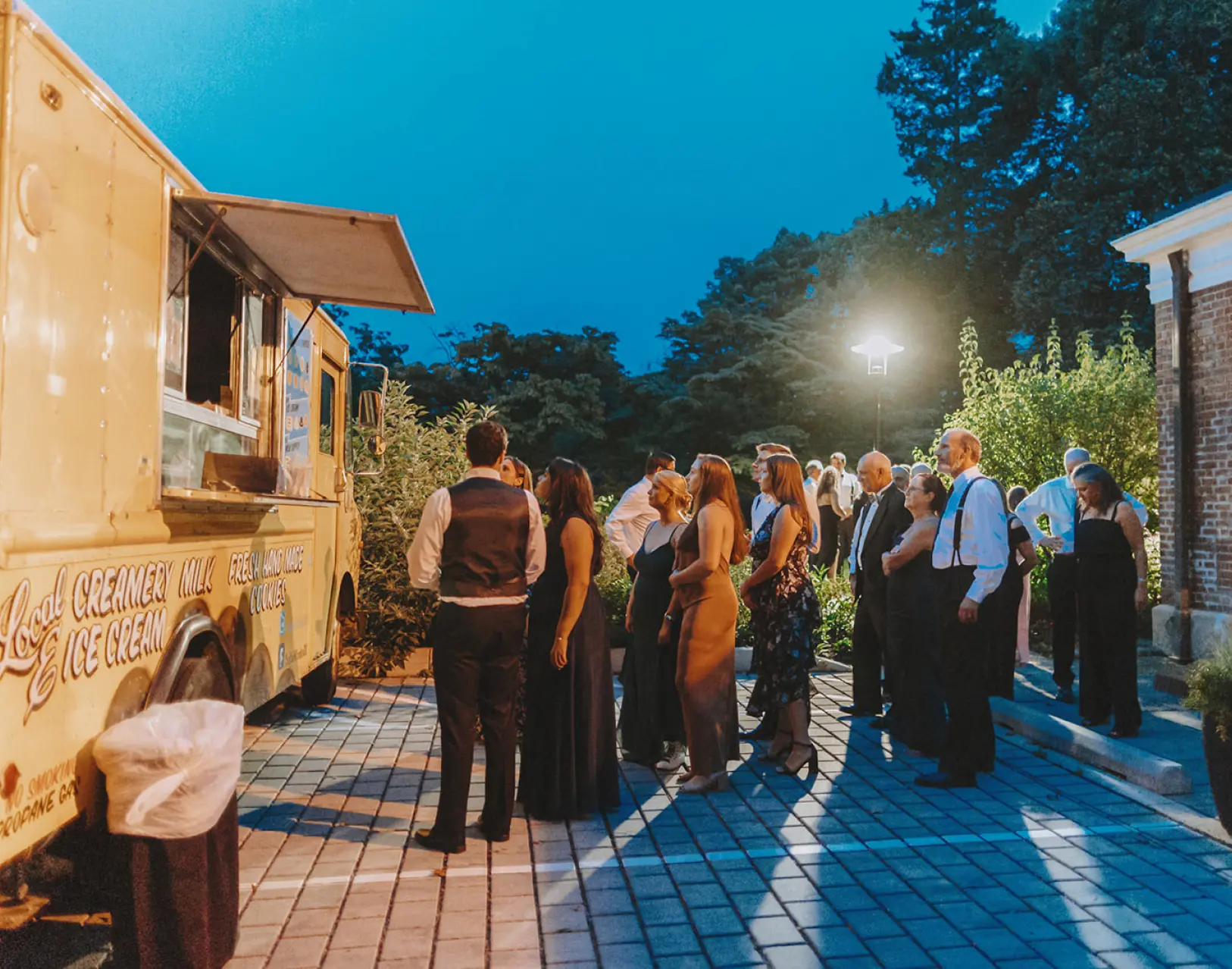 People standing outside a food truck at a social event