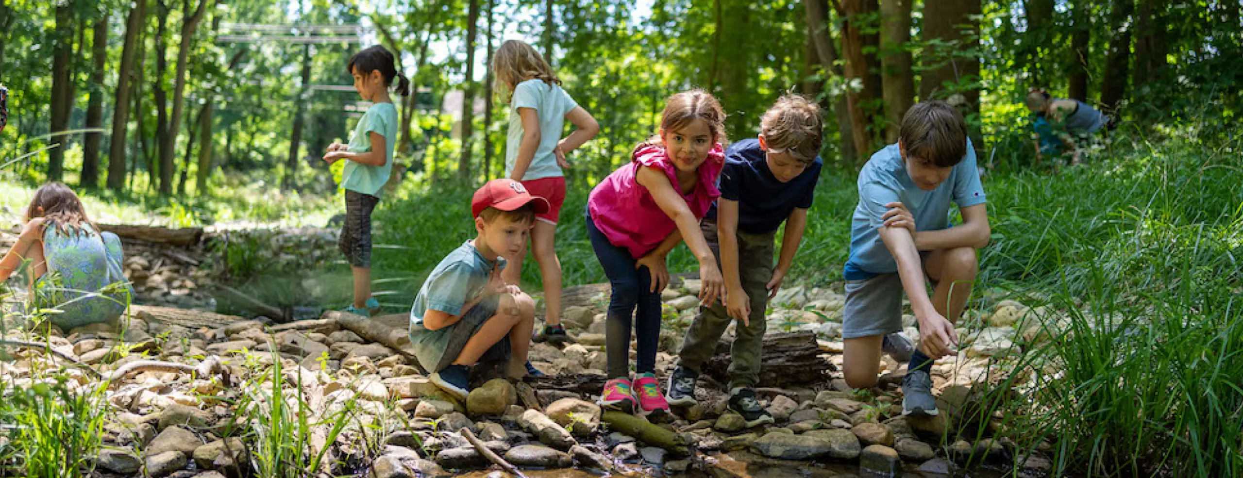 Kids exploring on the grounds of Woodend Sanctuary looking at something in the pond